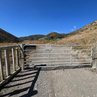 A metal gate with a small handwritten sign on it.