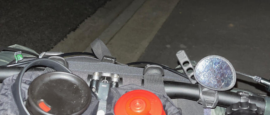 The loaded cockpit of my bicycle on a dark suburban street.
