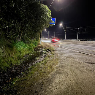 A car speeds past an informal parking area.