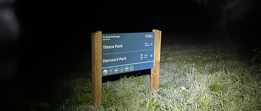 A blue and white sign pointing to Tõtara Park and Harcourt Park.