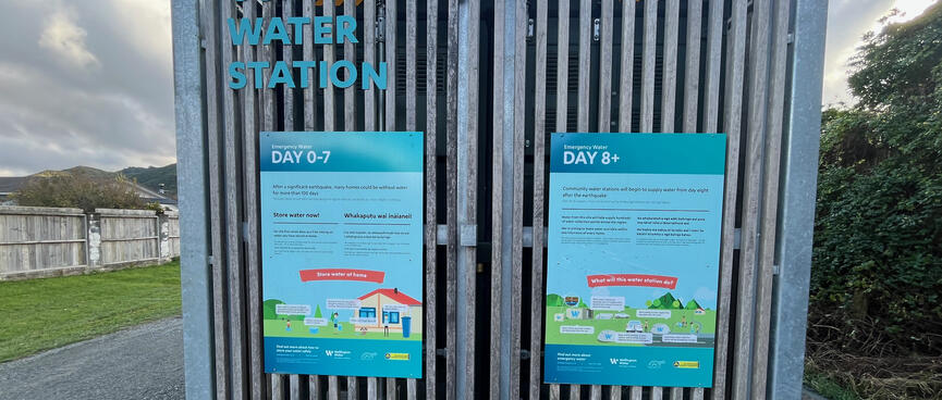 Signboards on a community water station explain that its purpose is to provide houses with water from day 8 onwards after a significant earthquake.