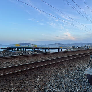 A jetty extends out from the coastline near railway tracks.