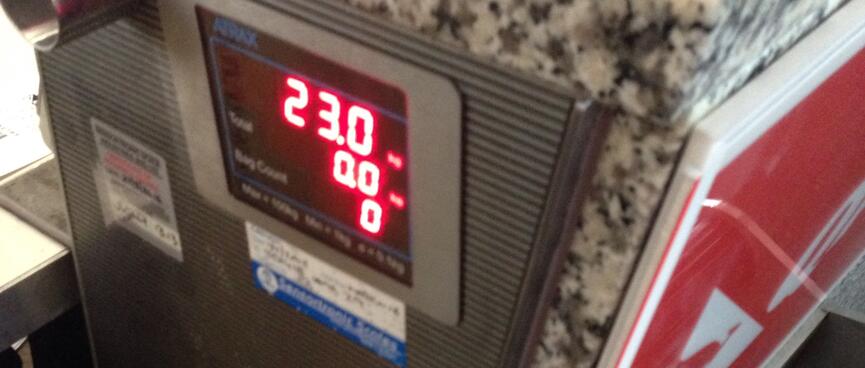 The LED readout at the check-in counter reads 23.0kg.