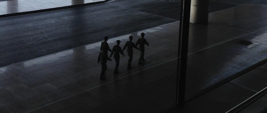 Five soldiers march in single file.