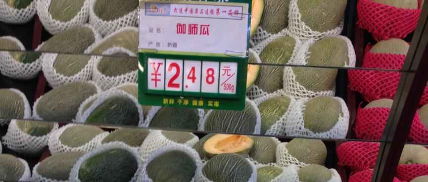 Stacked rock melons are wrapped in plastic mesh.
