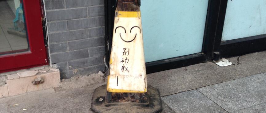 Pen marks on a road cone resemble a happy face.