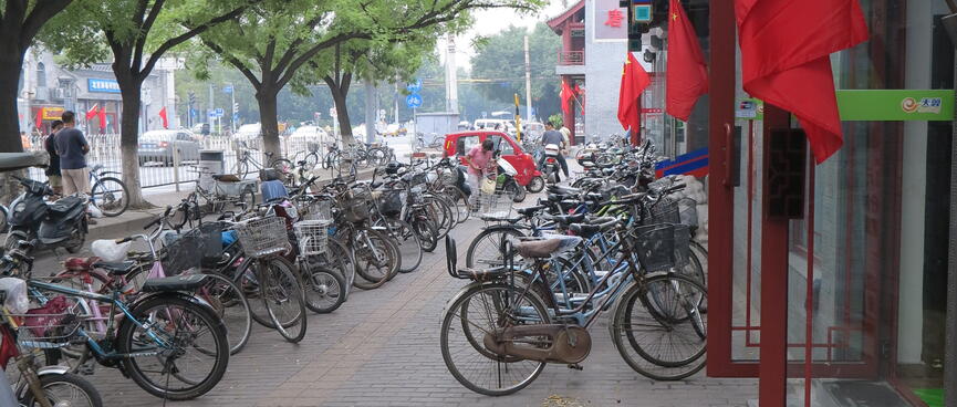 Bicycles are angle parked enmasse on the footpath.