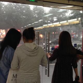 Young female shoppers stand inside the shop doors.