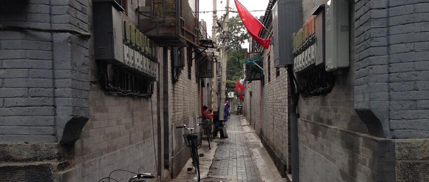 Bikes with baskets line an alleyway.