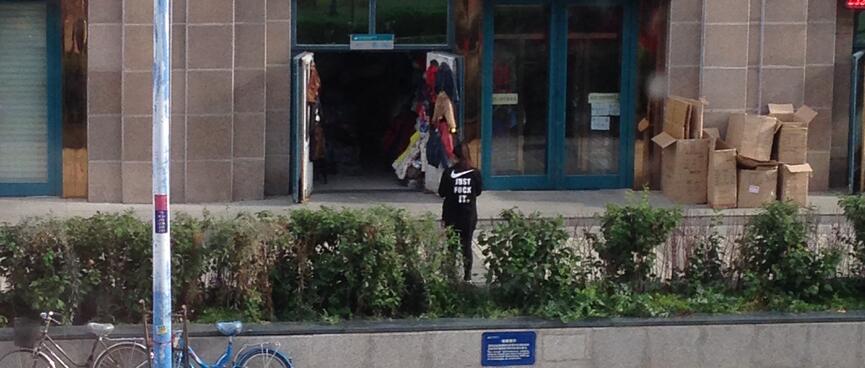 Standing outside a shop, local wears a Nike style t-shirt which reads ʼJust f*ck itʼ.