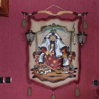 Chinggis Khan sits on a throne, dressed in furs and moccasins.
