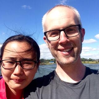 The wind whips Mandyʼs hair as we pose by the lake.