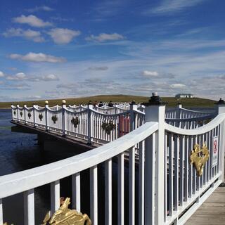 Fence pickets and posts dominate the view over the bridge.