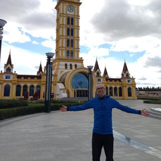 I spread my arms in front of an ornate clock tower.