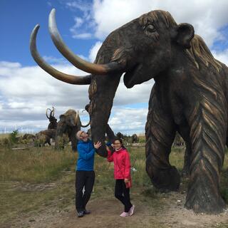 Mandy and I hold on to a mammothʼs long trunk.