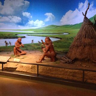 A reenactment of early people living on green steppes.
