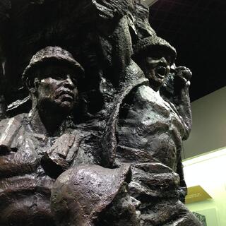 Metal statues depict bare chested miners wearing helmets.