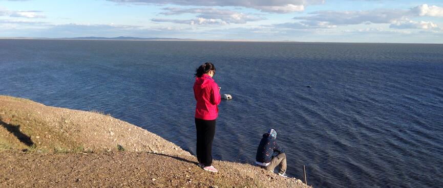 Mandy stands on a high point of the lakeshore with one of the guys.