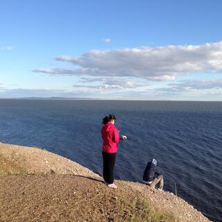 Mandy stands on a high point of the lakeshore with one of the guys.