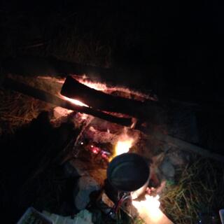 A billy sits on top of a roaring fire.