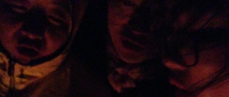 Three Chinese sing in the light of the campfire.