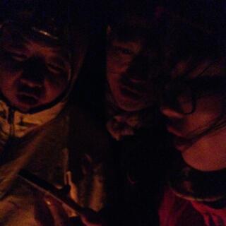 Three Chinese sing in the light of the campfire.