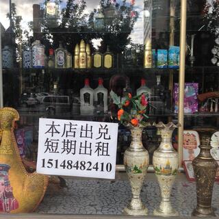 Ornate vases and bullet-shaped vodka bottles in a shop window.