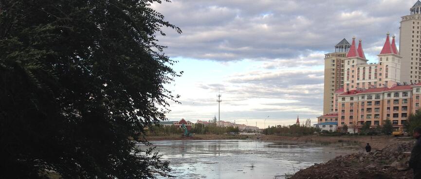 People stroll around the dirty banks of the local lake.
