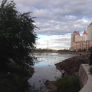 People stroll around the dirty banks of the local lake.