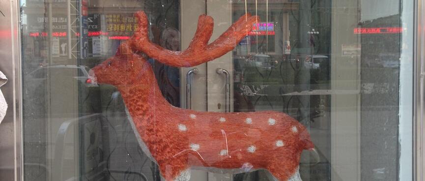 A model reindeer has white legs and a brown body with white spots.