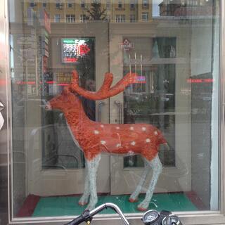 A model reindeer has white legs and a brown body with white spots.