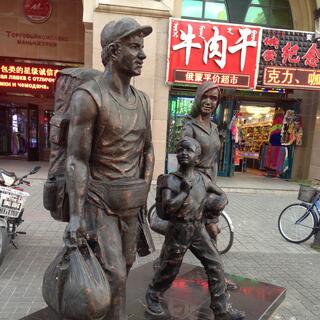 Bronze statues of a fit man, wife and child.