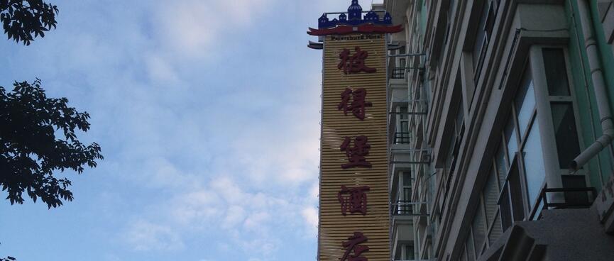 A large hotel in a tree lined street.
