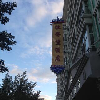A large hotel in a tree lined street.
