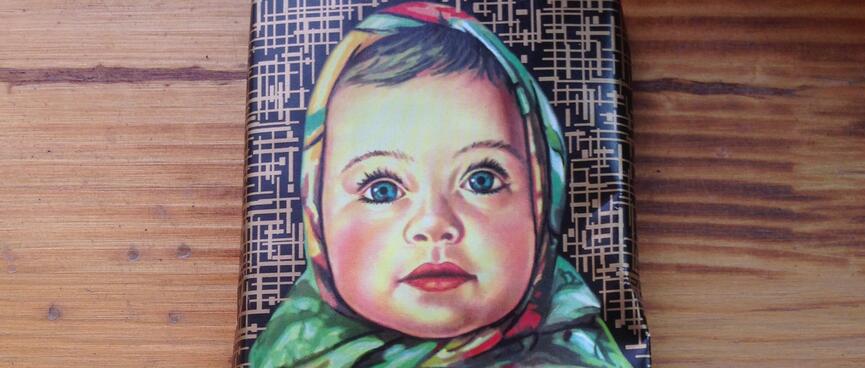 A chocolate wrapper has an illustration of a baby in a head scarf,