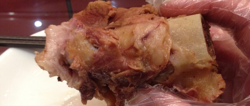 A thin plastic glove protects my hand from fatty pork-on-the-bone.