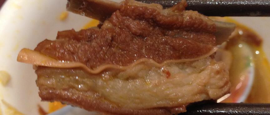 A chunk of pork, itʼs edges wrapped in a layer of fat.