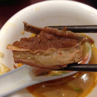 A chunk of pork, itʼs edges wrapped in a layer of fat.