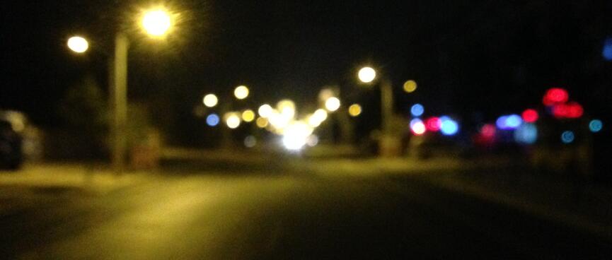 Blurred spheres light an urban street.