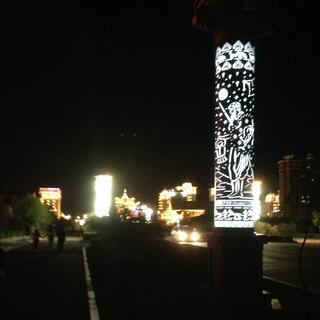 Ornate light art is wrapped around a lamppost.