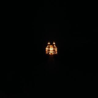 A church with two towers stands bright against the dark night sky.