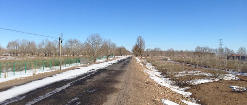 A country road with patches of snow.
