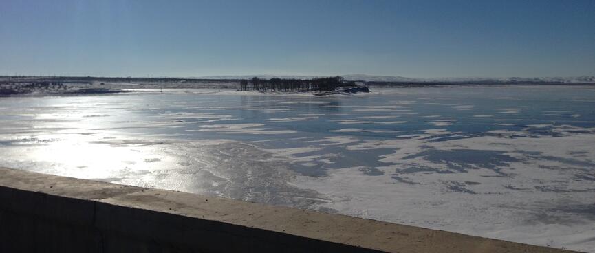 A frozen lake as viewed from the bridge.