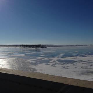 A frozen lake as viewed from the bridge.