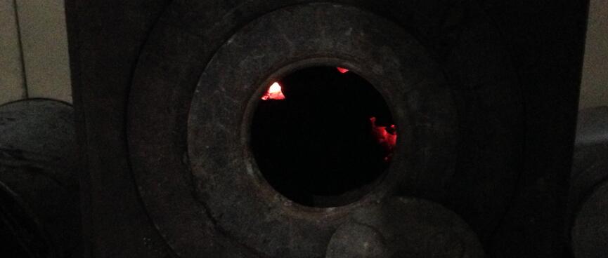 The pot belly stove was full of glowing coal embers.
