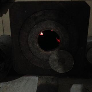 The pot belly stove was full of glowing coal embers.