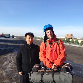 A Chinese man dressed in black and me in my cycling gear.