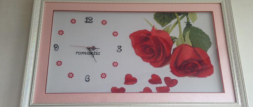 A framed clock with a crocheted background.