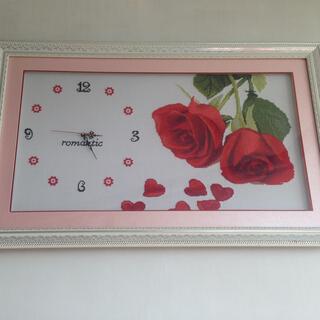 A framed clock with a crocheted background.