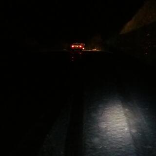 My bike light illuminates a small patch of the snowy road ahead.